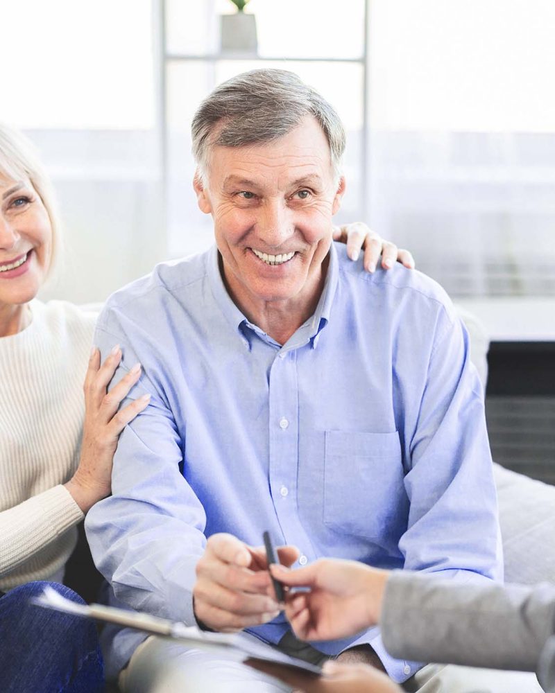 happy-mature-couple-talking-to-financial-advisor-a-UC8J9AW.jpg